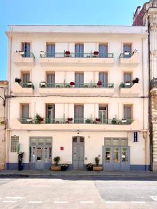 a large white building with windows and balconies at Le National Sète Centre Gare,Ascenseur in Sète