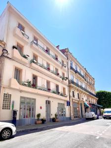 a large white building with balconies on a street at Le National Sète Centre Gare,Ascenseur in Sète