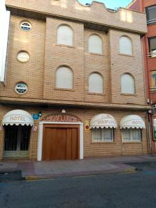a large brick building with a wooden door on it at Hotel Miraflores in Alcobendas