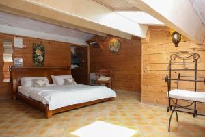 a bedroom with a bed in a room with wooden walls at Hôtel CASITA in Puygiron
