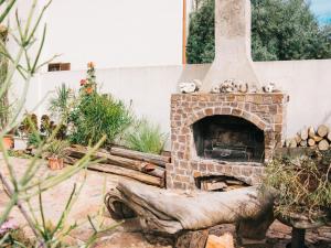 een stenen open haard in een tuin met planten bij Apartment Rosa Dei Venti by Interhome in Santa Maria Navarrese
