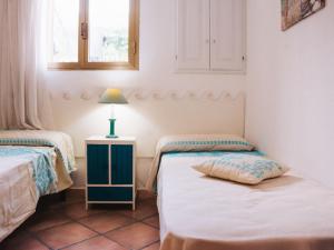 een kamer met twee bedden en een lamp op een tafel bij Apartment Rosa Dei Venti by Interhome in Santa Maria Navarrese