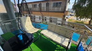 a balcony with two swings and a table and a table at SAB Luxury Apartaments 2 Saturn in Saturn