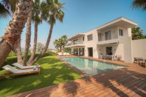 a house with a swimming pool and palm trees at FRGK Luxury Villa Cannes Croix des Gardes in Cannes