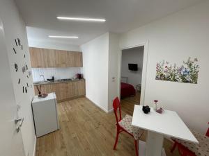 a white kitchen with a table and a refrigerator at Residenza Redenzione - Bread House in Venafro