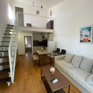 Una sala de estar con un sofá blanco y una escalera. en Village Club Thalassa, en Mèze