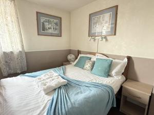 a bedroom with a bed with blue and white pillows at The Aberford in Blackpool +72 photos