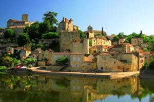 a town on a hill next to a body of water at Chalet Quercy in Mauroux
