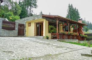 une petite maison jaune avec une allée en pierre dans l'établissement Casa Adrian, à Predeal