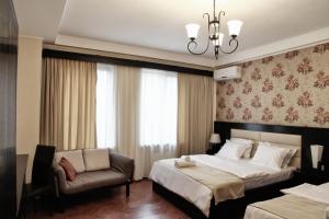 1 dormitorio con 2 camas, sofá y lámpara de araña en Hotel Four Brothers en Tiflis