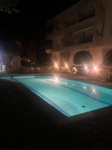 a swimming pool at night with lights on it at Harmony Apartment in Kallithea Halkidikis