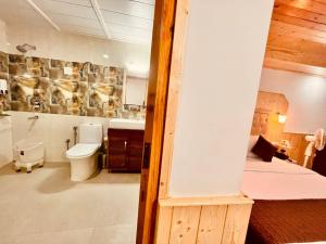 bagno con letto, servizi igienici e lavandino di Hotel Himalayan Valley View Retreat - Best Selling Riverside Hotel in Manali a Manāli