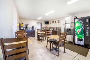 a restaurant with tables and chairs and a refrigerator at Hardin Lodge By Capital O Little Bighorn Battlefield I-90 in Hardin