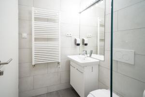 a white bathroom with a toilet and a sink at Adventure Hotel Hof in Hof