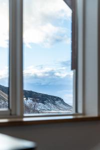a window with a view of a snow covered mountain at Adventure Hotel Hof in Hof
