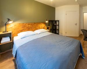 a bedroom with a large bed with a blue blanket at Adventure Hotel Hof in Hof +50 photos