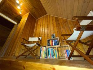 FuhlendorfにあるFischerhuus am Darß - Ostsee Urlaub gratis Parkplatz, Wlanの椅子2脚と本棚付きの部屋