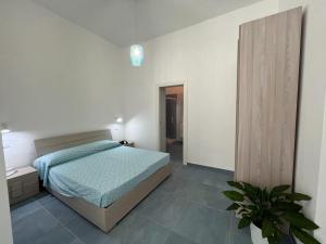 a bedroom with a bed and a potted plant at Otranto - appartamento sul mare, parcheggio privato in Otranto