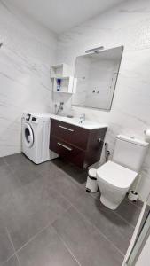 ein Badezimmer mit Toilette, Waschbecken und Waschmaschine in der Unterkunft Feels like home in Paraiso in Adeje