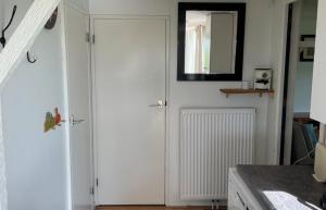 a white door in a kitchen with a mirror at Chalet de Sudhoek in Vrouwenparochie