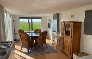 a kitchen with a table and chairs in a kitchen at Chalet de Sudhoek in Vrouwenparochie