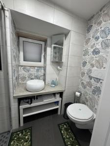 a bathroom with a toilet and a tv on the wall at Semplice Dimora Ostuni in Ostuni +41 photos