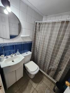 Un baño con inodoro, lavabo y espejo. en Departamento Sanlo, en Mendoza