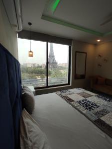 a bedroom with a view of the eiffel tower at WK Suites in Rāmkot +12 photos