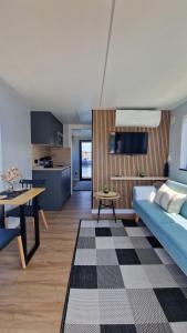 a living room with a blue couch and a table at Alma Flotante Muxía in Muxia