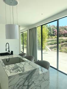 a kitchen with a marble counter and a large window at White Olive Villas in Santarém +74 photos