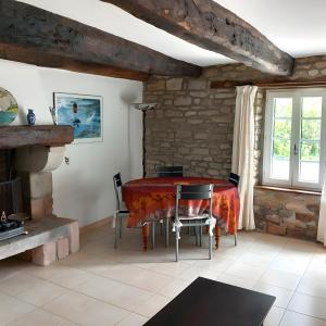 a dining room with a red table and chairs at Maison Le Clos Nalet in Matignon