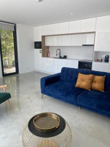 a living room with a blue couch and a table at White Olive Villas in Santarém