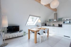 a kitchen with a dining room table and a window at Am Horizont No 2 für 2-4 Pers, 2 Schlafz, Babybett, Südbalkon, kostenloser Parkplatz 400 Meter zum Strand in Zingst