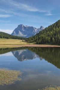 een weerspiegeling van een berg in een lichaam van water bij Casa Montagna in Canale San Bovo