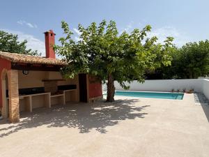 een huis met een boom naast een zwembad bij Villa Adela in Oliva