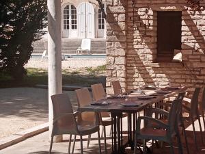 ChamaretにあるVilla chez magaliの建物前の長い木製テーブルと椅子