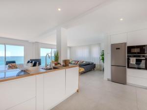 a kitchen with white cabinets and a living room at Holiday Home NANOUSH by Interhome in Albufeira
