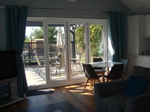 a living room with a sliding glass door with a table and chairs at Spring Paddocks B&B in Furneux Pelham
