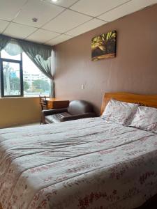 a bedroom with a large bed and a window at Hostal Abu Dhabi in Cuenca