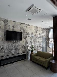 a living room with a couch and a tv on a wall at Capital Hotel Long Island City in Queens