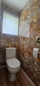 a bathroom with a toilet and a window at The Lucky 7 in Hemsby +13 photos