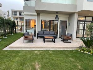 a patio with a couch and chairs on a lawn at ازهى السخنه Azha in Ain Sokhna