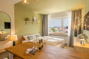 a hotel room with a bed and a table with wine glasses at Boutique-Apartment Rubiblick in Oberstdorf