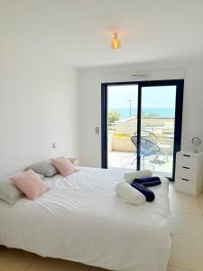 una camera da letto con un grande letto bianco con asciugamani sopra di Niosète, Exceptional Panoramic Sea View Luxury & Comfort a Sète
