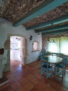 a kitchen and dining room with a table and chairs at La petite maison aux lézards in Le Garn