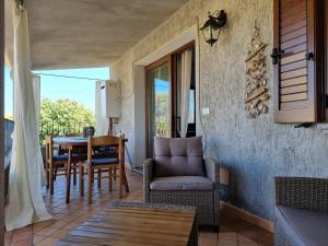a balcony with a couch and a table and chairs at Leo's House - BUDONI SWEET HOME in Budoni