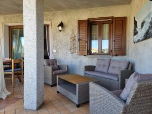 a patio with wicker chairs and a table on a porch at Leo's House - BUDONI SWEET HOME in Budoni