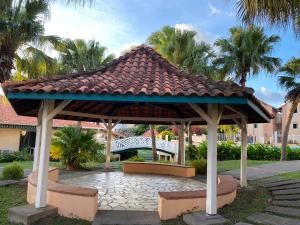 un gazebo con tetto e panca di Cocon Tropical a Sainte-Anne
