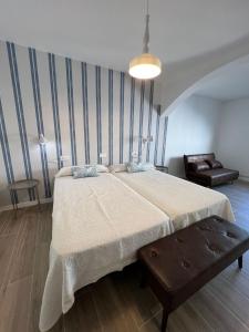 una camera da letto con un letto grande e una sedia di Hostal Terraza Miramar SL a Boiro Altre 59 foto