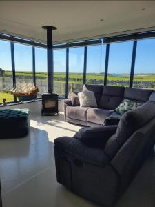 Country Cottage, Stunning Views في ترالي: غرفة معيشة مع أريكة ومدفأة